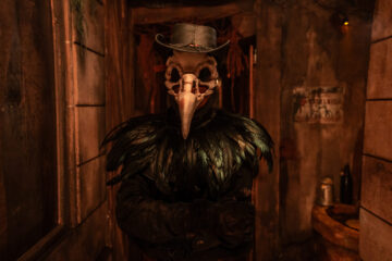 The taxidermist character - wearing a crow mask and black feathers